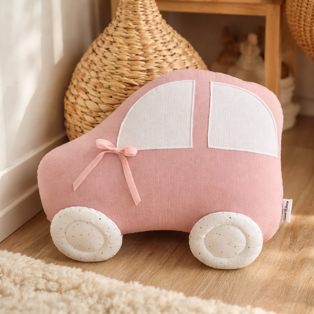 Pink handmade car shaped pillow for kids room in cotton muslin fabric with white windows and decorative bow