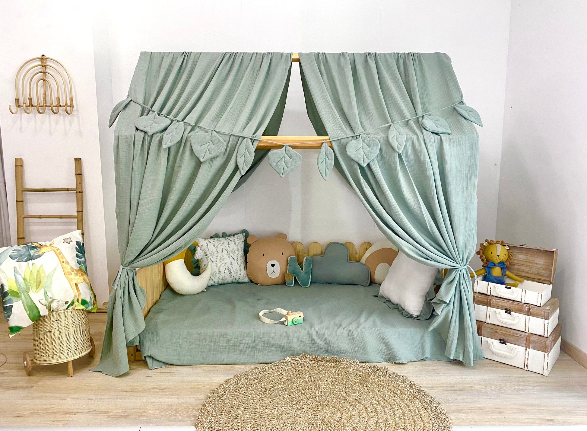 Sage green canopy over floor bed in kids room