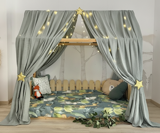 Sage grey canopy over Montessori floor bed with star tiebacks