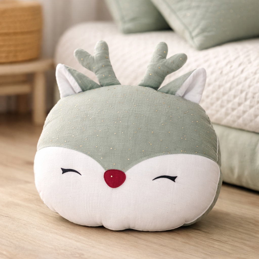 Round cushion shaped like a deer head on a wooden floor with a blurred background