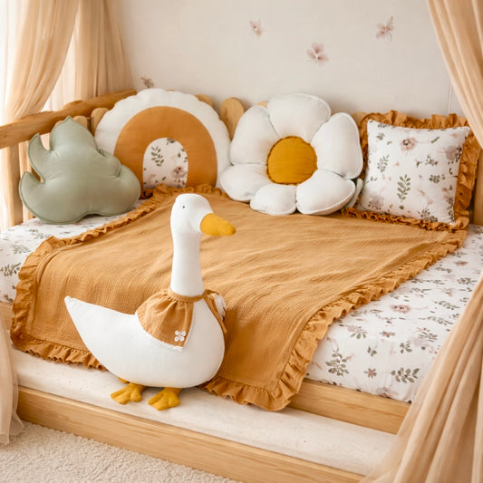 Children's room with a bed decorated with soft pillows and a large toy duck.