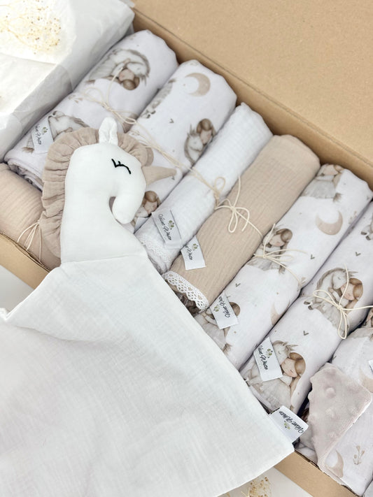 Box of baby blankets with animal patterns and a plush toy in a neutral color scheme.