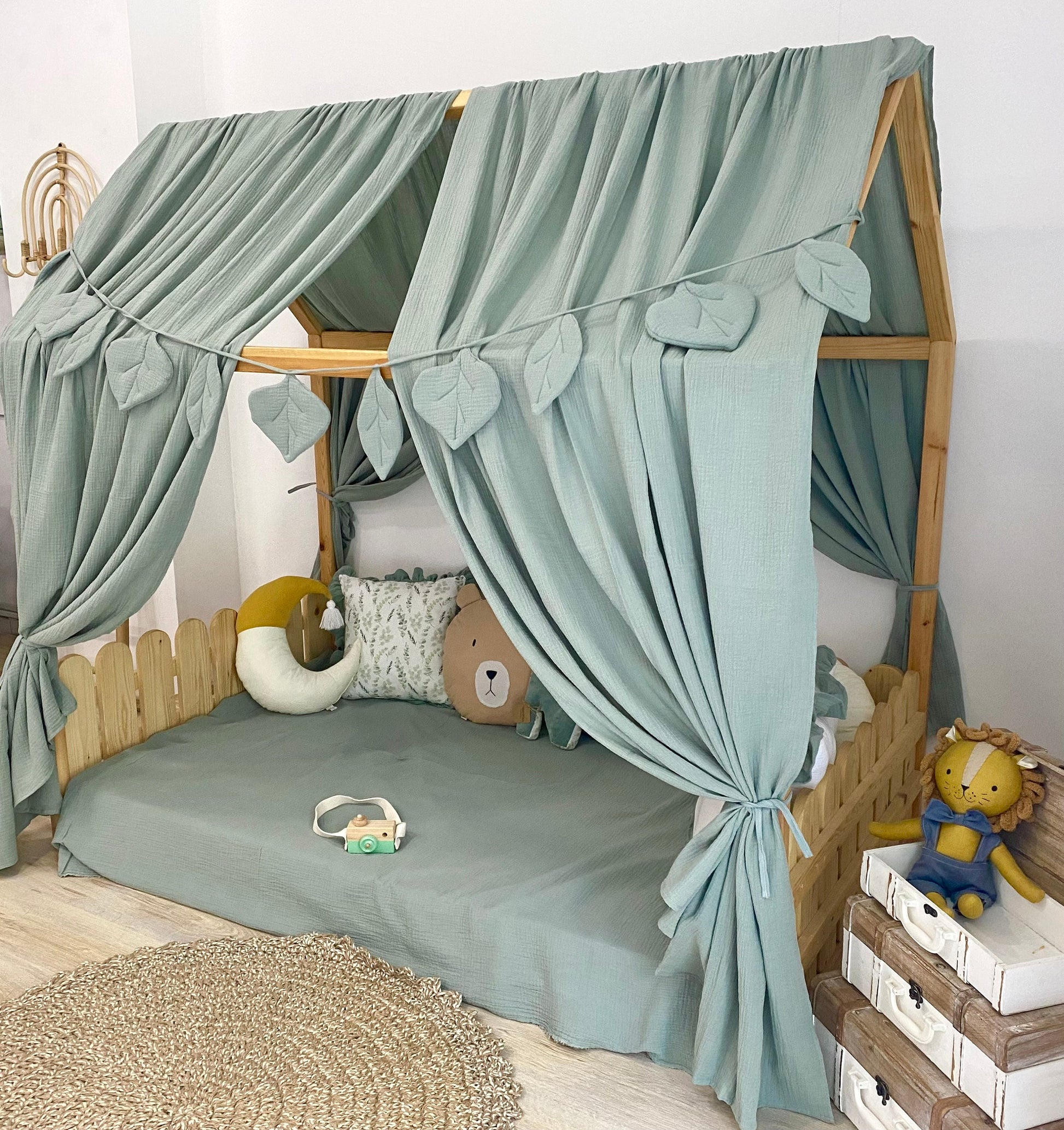 Sage green canopy over floor bed in kids room